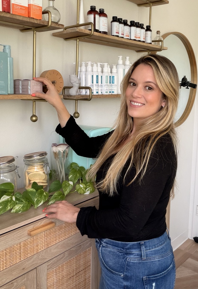 Brittany reaching for a product on the studio's open shelves