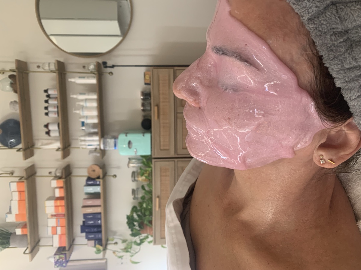 A client resting mid-facial under the pink masque